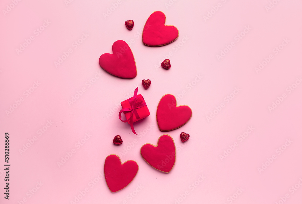 Composition with heart shaped cookies for Valentines day with gift on color background