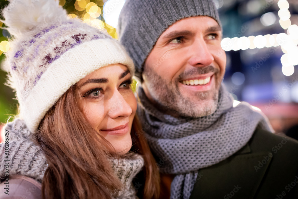 Portrait of a loving couple among Christmas street decorations during winter holidays