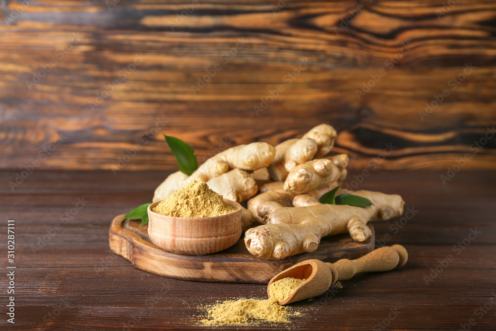 Fresh and ground ginger on wooden table