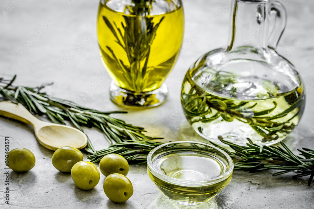 oil in carafe with spices and olive on stone background