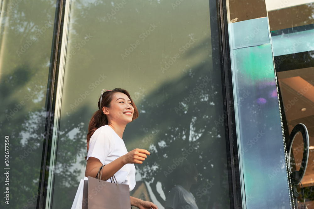 购物的女人开心地看着户外的复制空间。