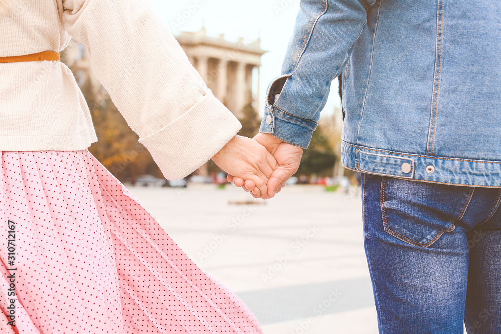 Happy mature couple holding hands outdoors on autumn day