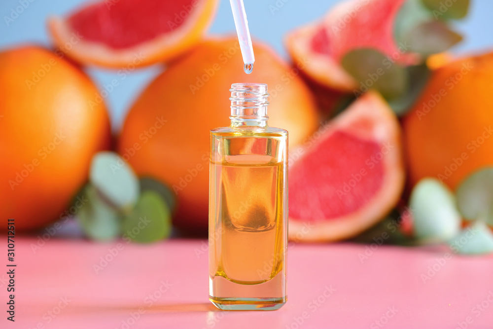 Bottle of grapefruit essential oil on table