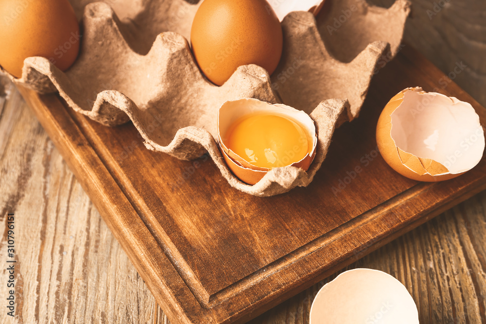 Package with fresh eggs on wooden table