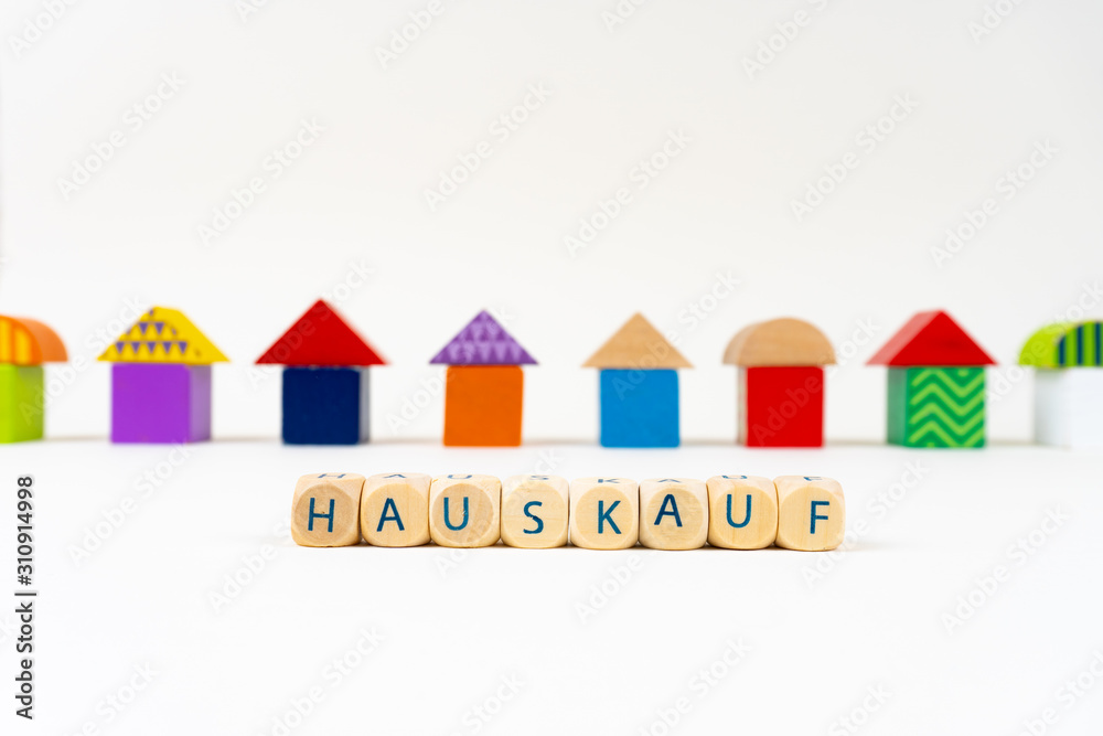 彩色玩具前写着Hauskauf（德语，用于购买房地产）字样的木块