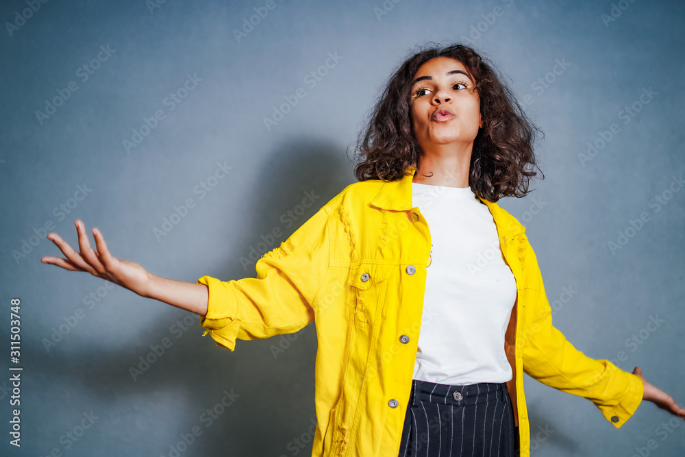 Positive human emotions. Portrait of happy emotional teenage girl with curly hair streched hands pal