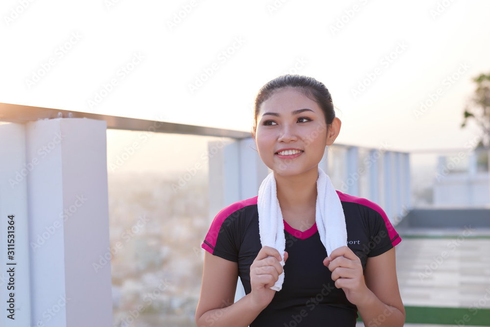 健康美丽的亚洲女运动员穿着带毛巾的运动服