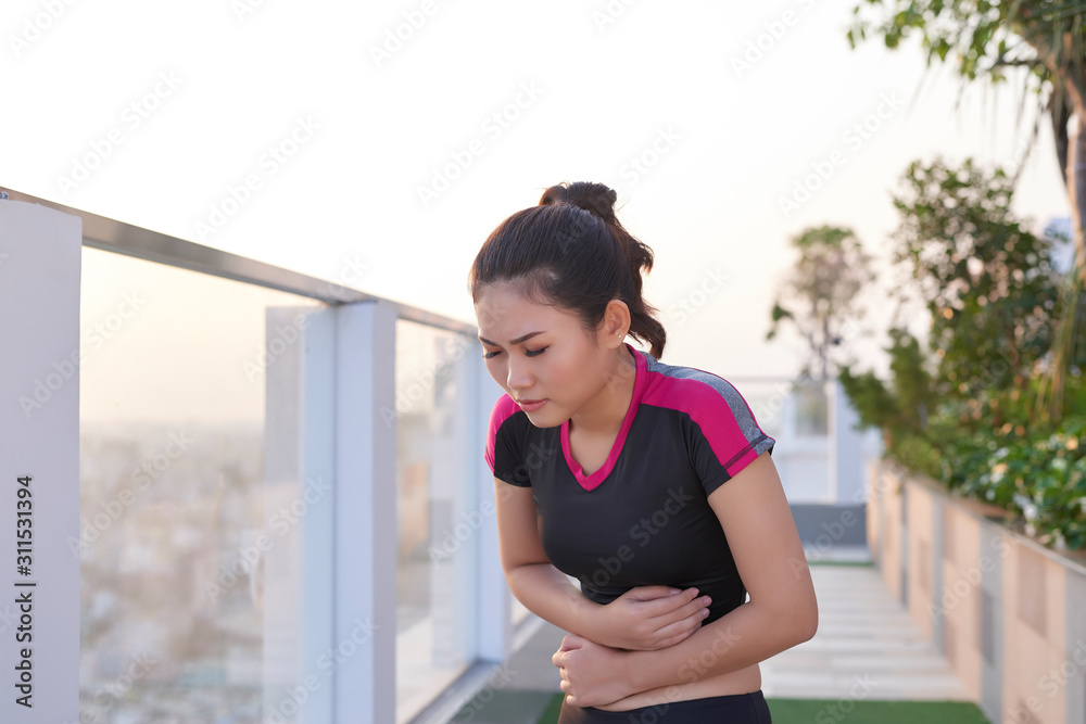 运动女性在公园里胃痛