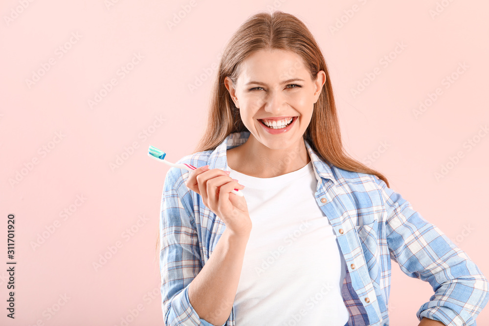 Young woman with toothbrush on color background