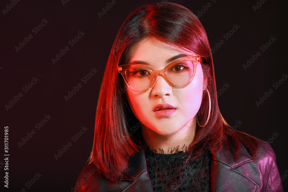 Portrait of young Asian woman on dark background