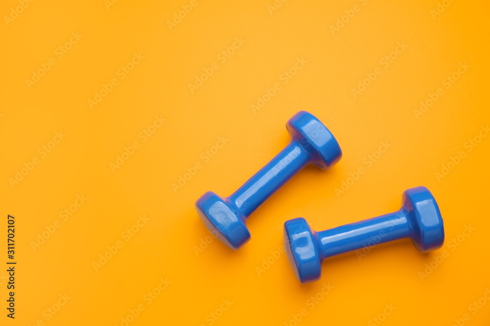 New dumbbells on color background