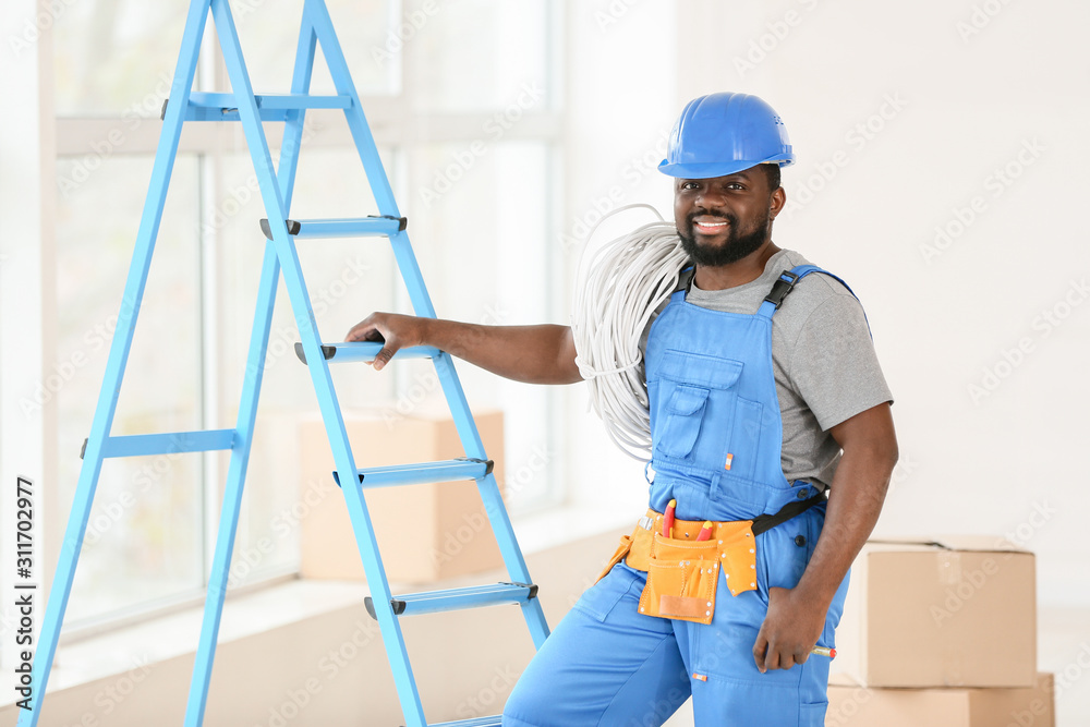 Portrait of African-American electrician in room