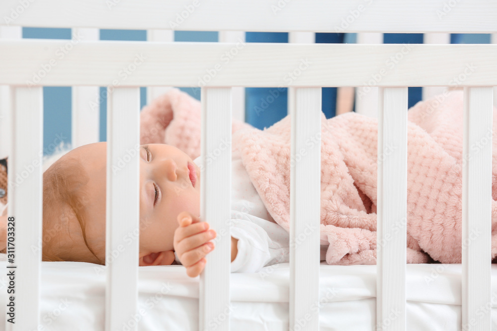 Little baby sleeping in bed, view through railing