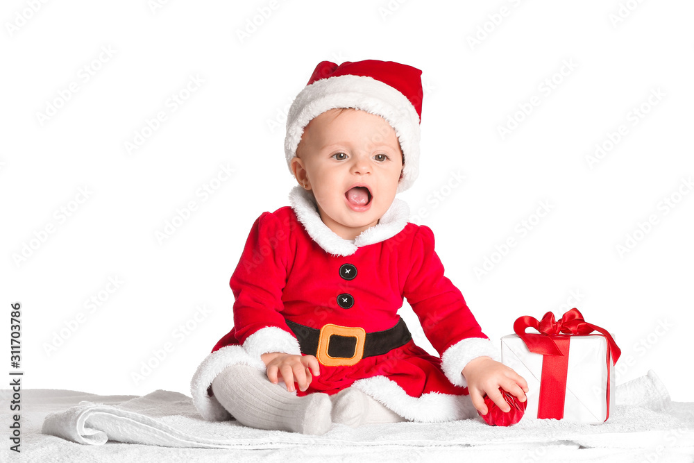 Cute little baby in Santa Claus costume and with Christmas gift on white background