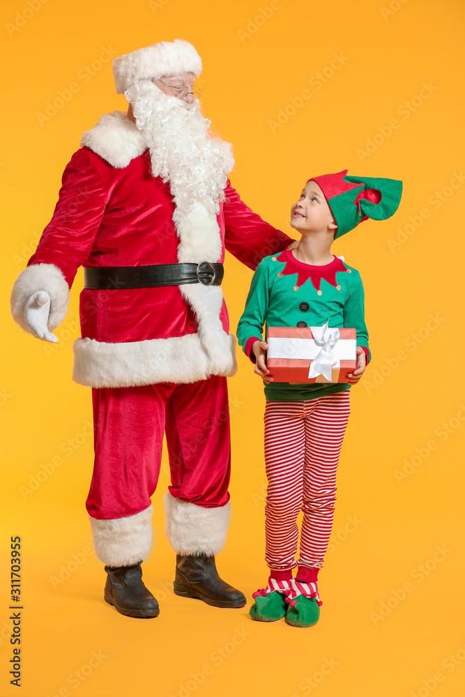 Santa Claus and little elf kid with gift on color background