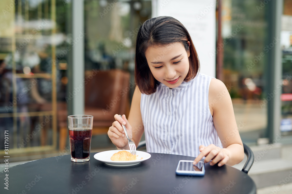 亚洲女性在咖啡馆使用智能手机