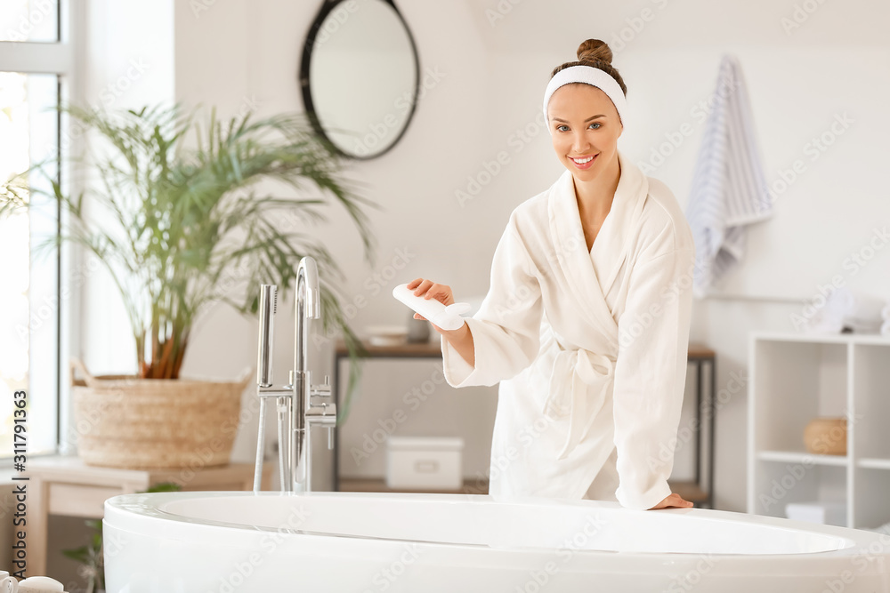 Beautiful young woman preparing relaxing bath