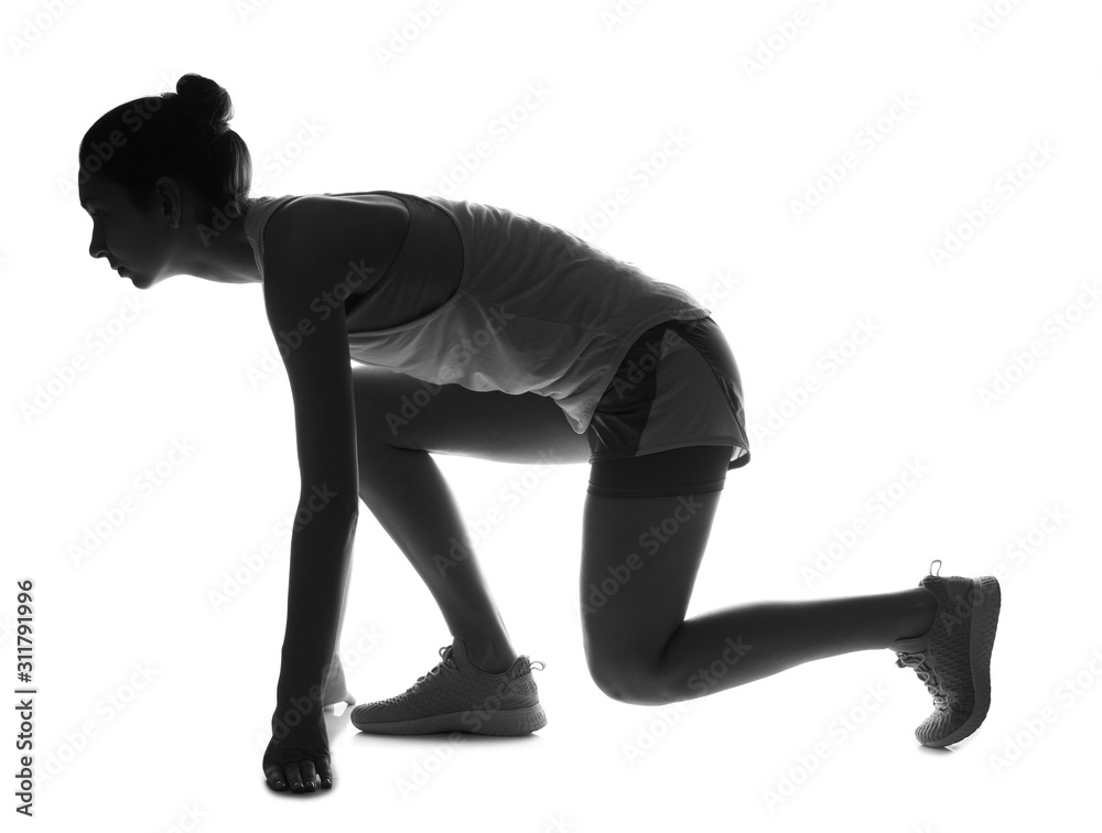 Silhouette of sporty young woman in crouch start position on white background