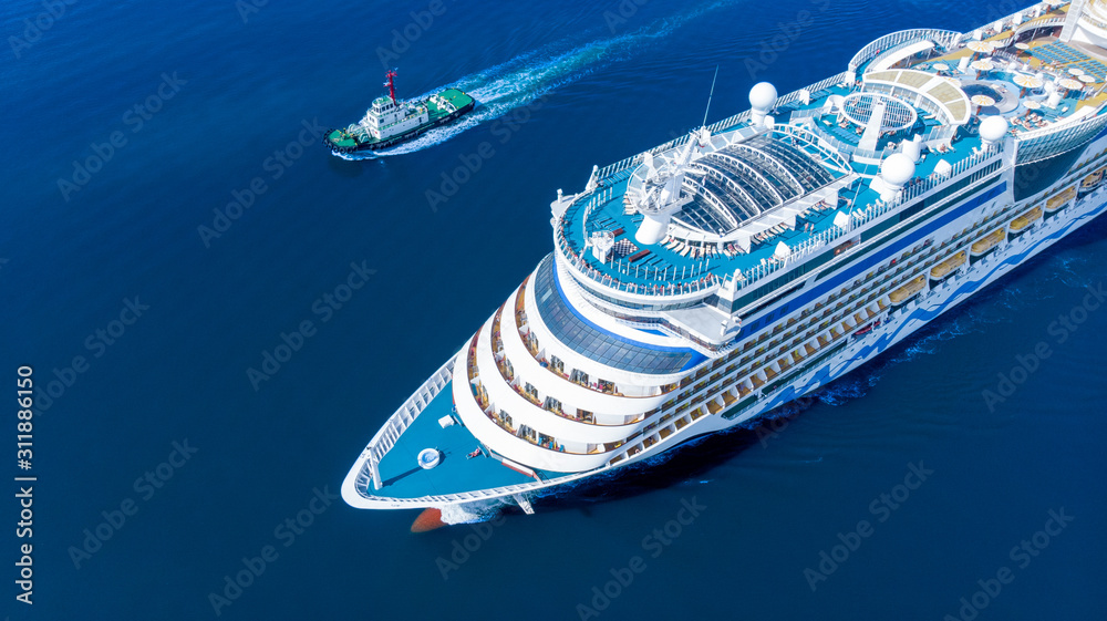 Aerial view of beautiful white cruise ship above luxury cruise running with tug boat in the ocean se