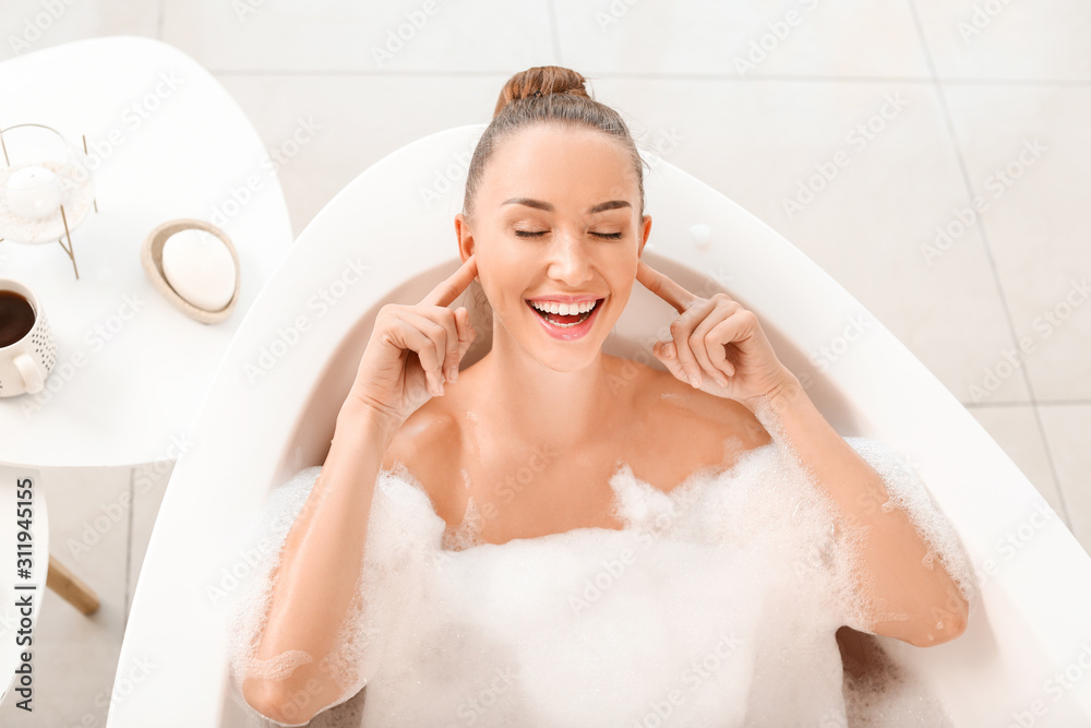 Beautiful young woman relaxing in bathtub