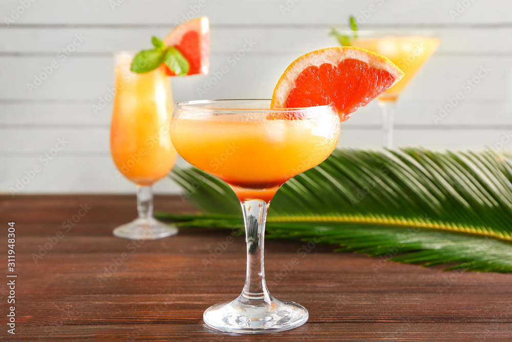 Glass of fresh citrus juice on table