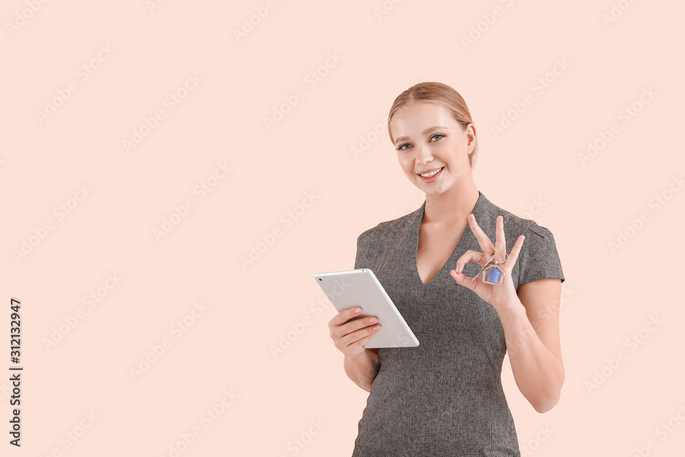 Female real estate agent with tablet computer and key on color background