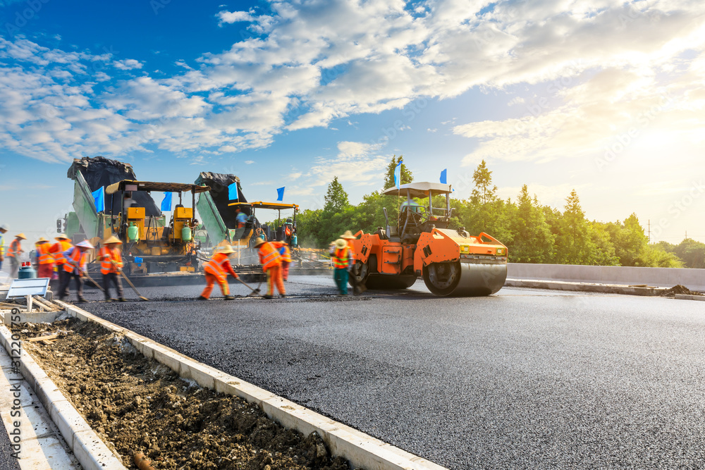 Construction site is laying new asphalt road pavement,road construction workers and road constructio