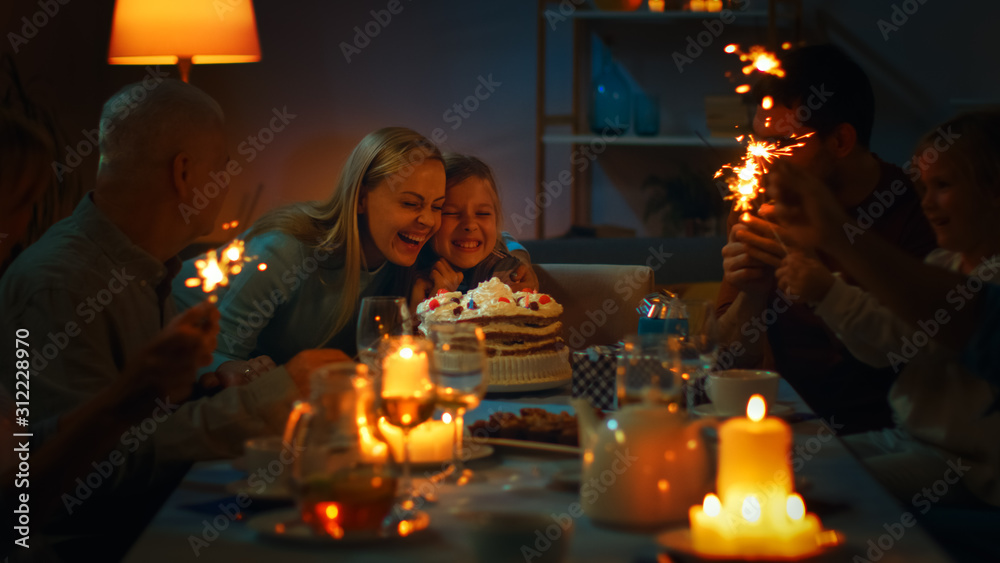 可爱小女孩在餐桌上庆祝生日，妈妈吹完后拥抱女儿