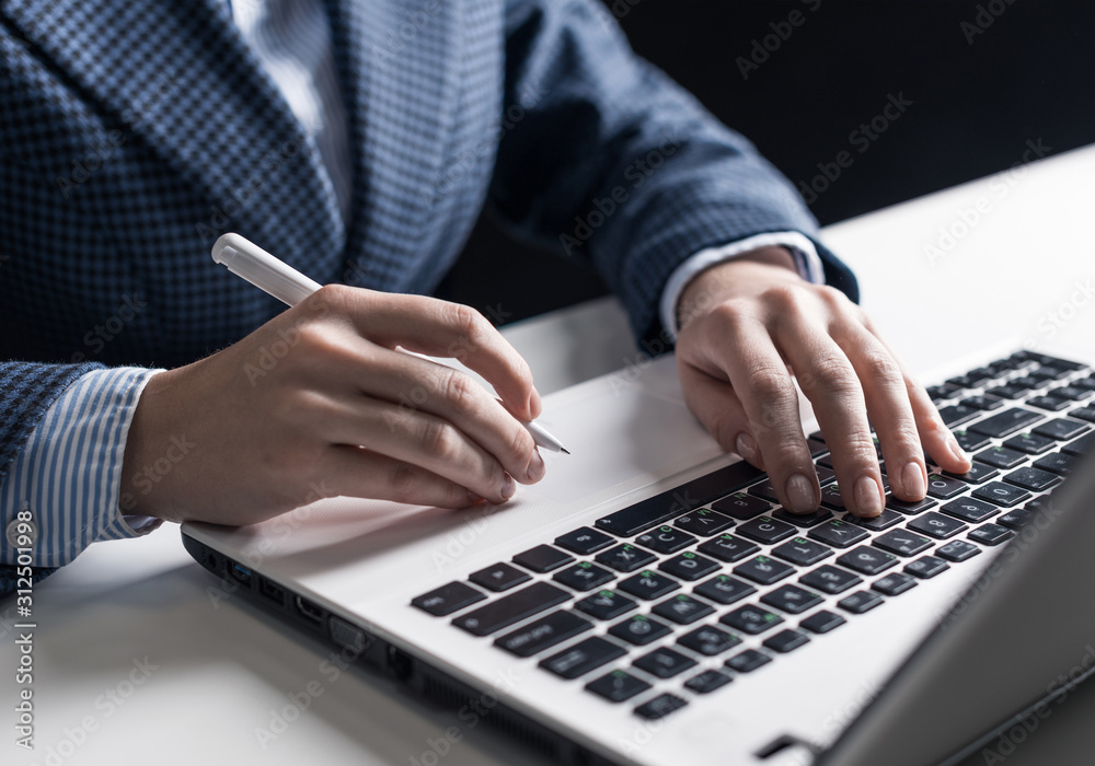 Man in business suit sitting at desk with laptop