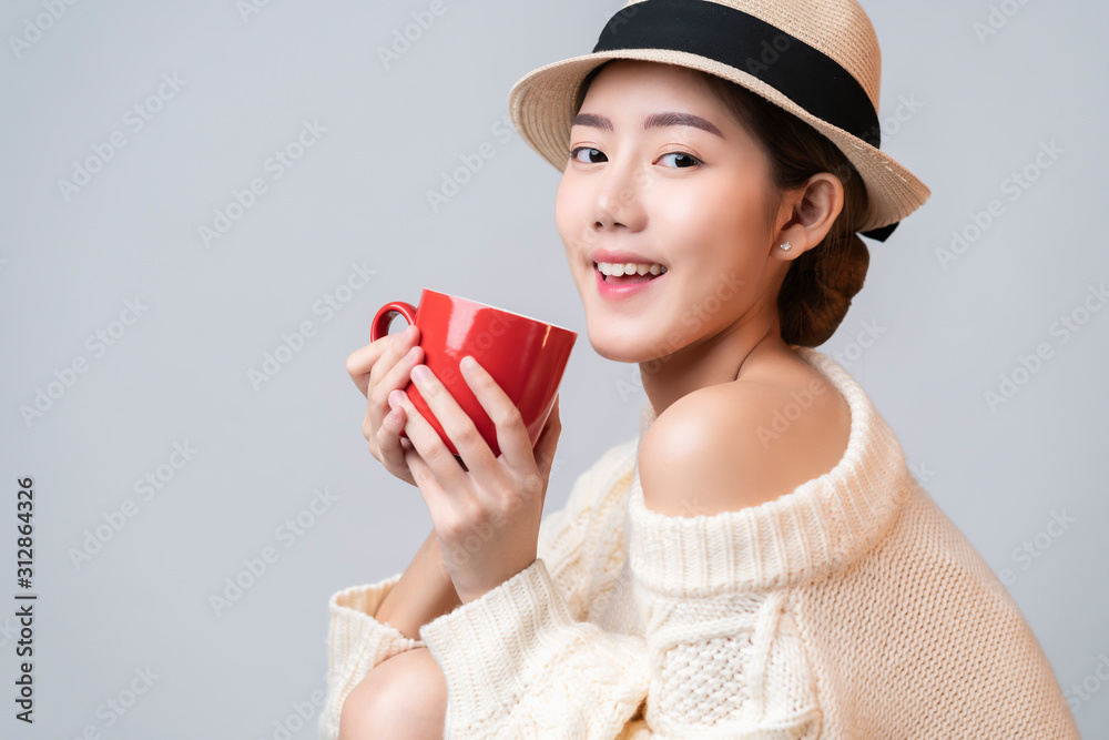 portrait of beautiful asian female in summer travel dress hand hold red ceramic cup of hot drinh wit