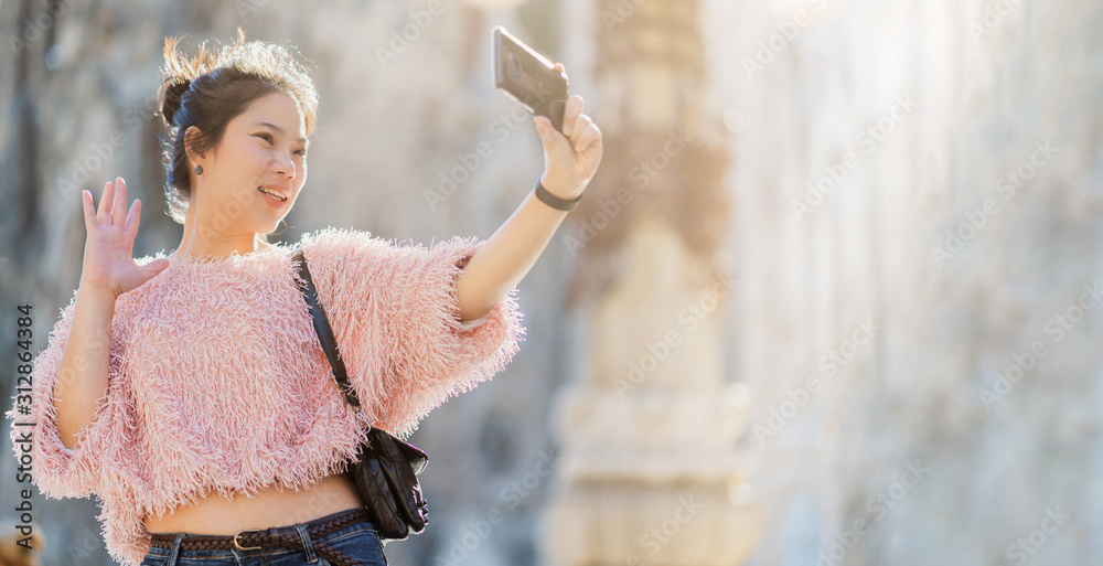 特写亚洲女性手持智能手机自拍旅行者，背景为房屋建筑，亚洲pho