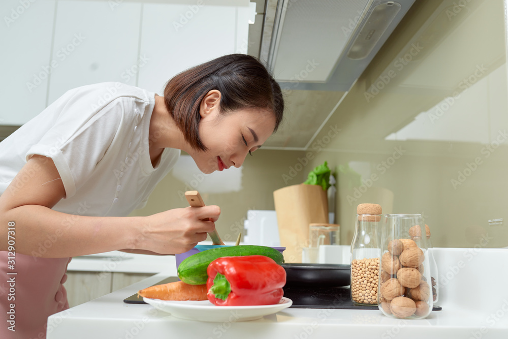 年轻女性在厨房做饭。健康食品。饮食理念。健康生活方式。在Hom做饭