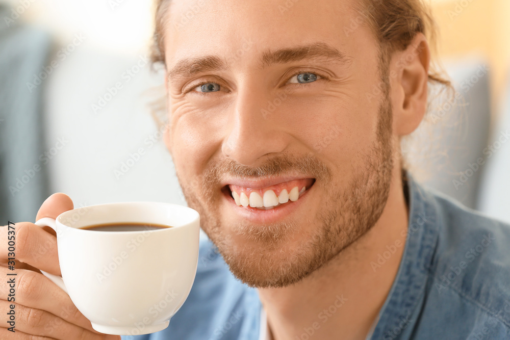 Handsome man drinking coffee at home