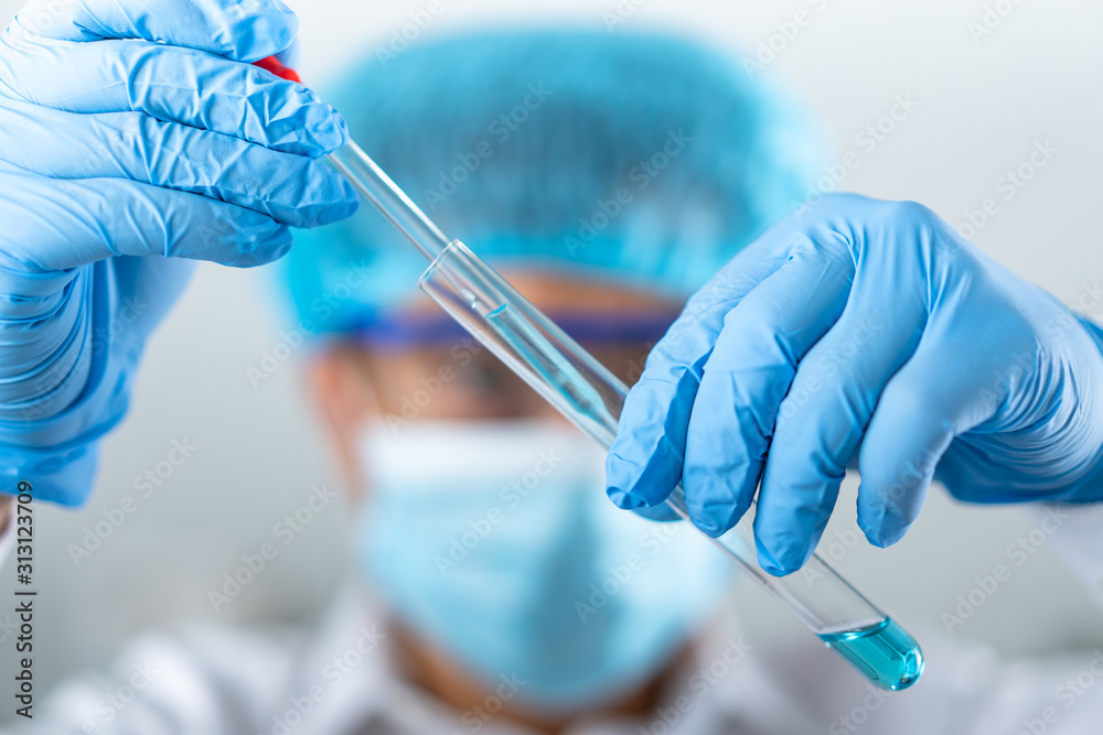 man holding test tube with fluid, making laboratory research