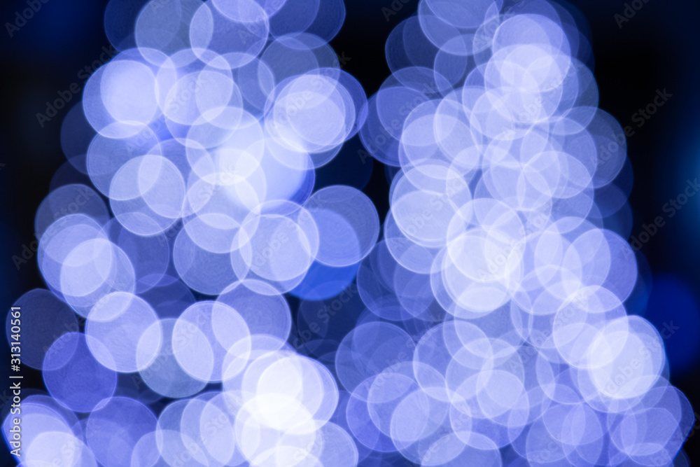 A picture of a multicolored bokeh light on a pedestrian street decorated on a tree from a lamp or ca