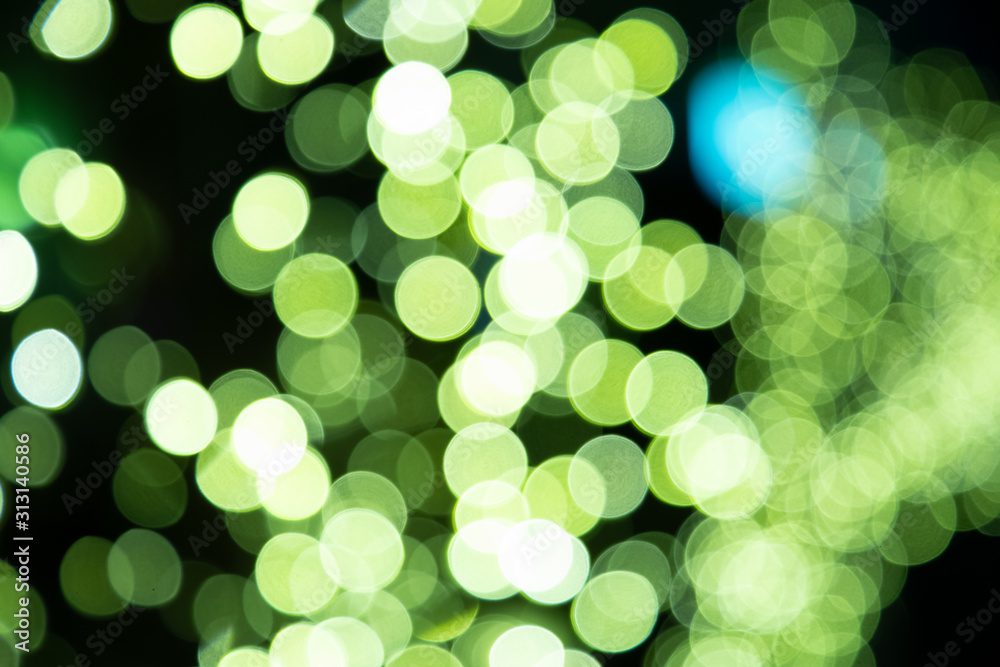 A picture of a multicolored bokeh light on a pedestrian street decorated on a tree from a lamp or ca