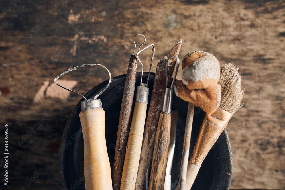 Tools for forming clay on  wooden background..