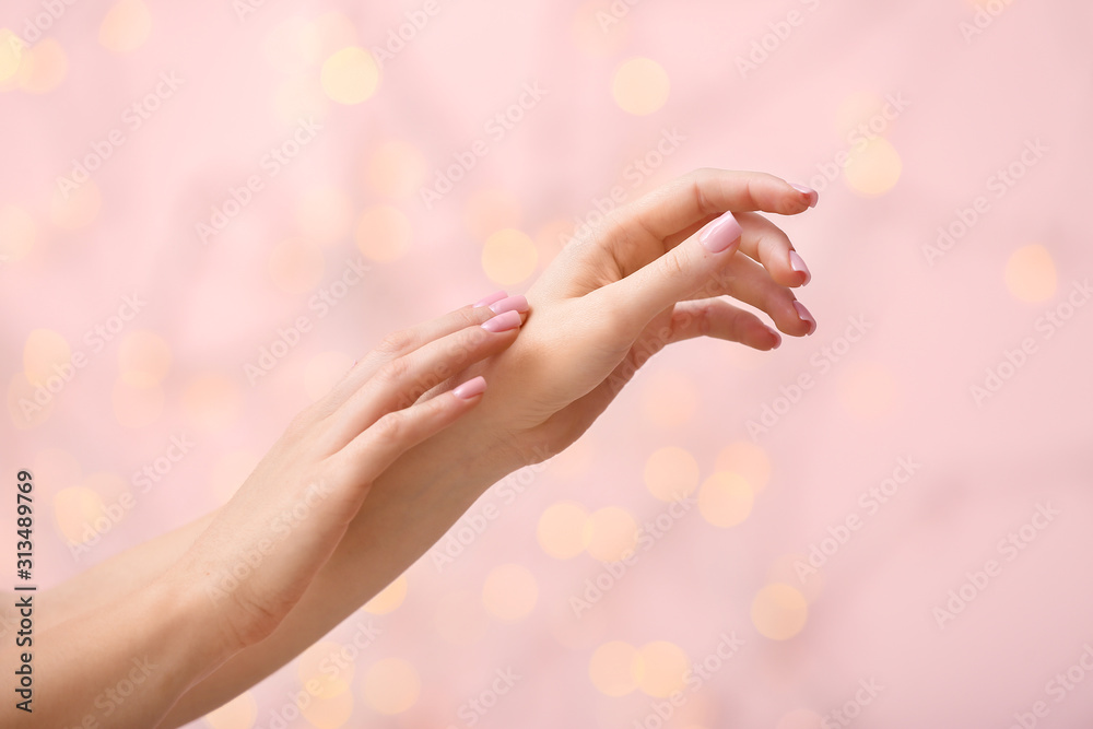 Hands of young woman on color background