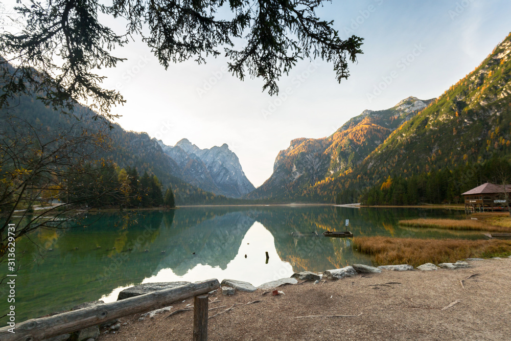 Dolomites mountains with reflection in Lago di Dobbiaca lake at autumn. Italy