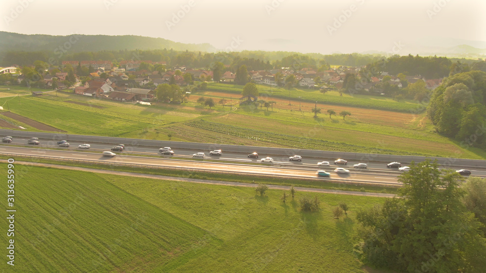 空中：金色的天空照亮了繁忙道路上行驶的车辆。