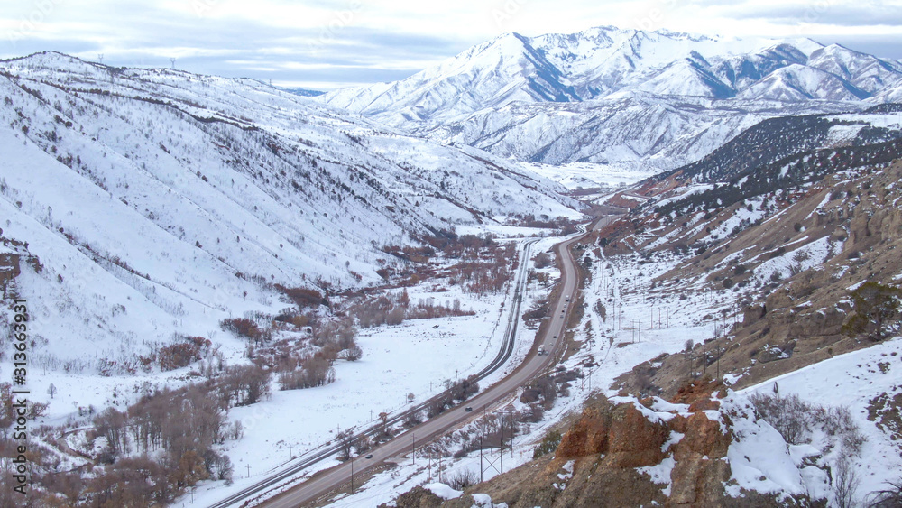 无人机：汽车和卡车沿着通往雪山的风景优美的高速公路行驶