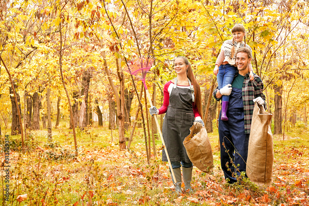 Family cleaning up autumn leaves outdoors