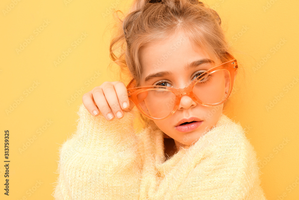 Cute fashionable girl with sunglasses on color background