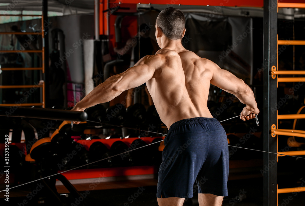 Sporty muscular man training in gym