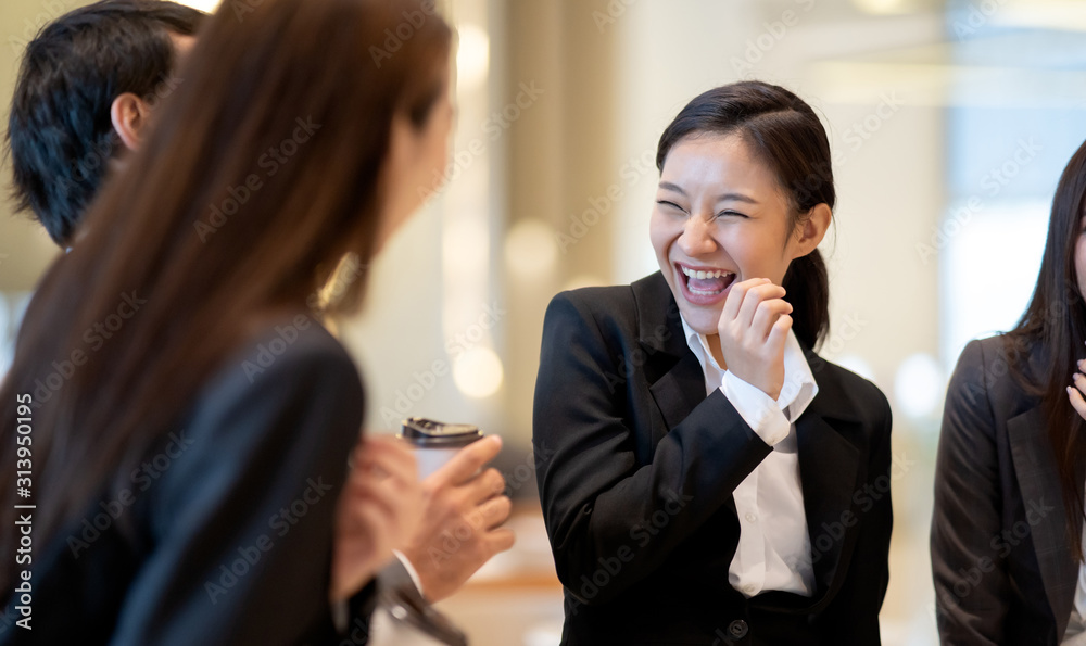 亚洲商人在办公楼里谈笑风生。年轻商人和女商人