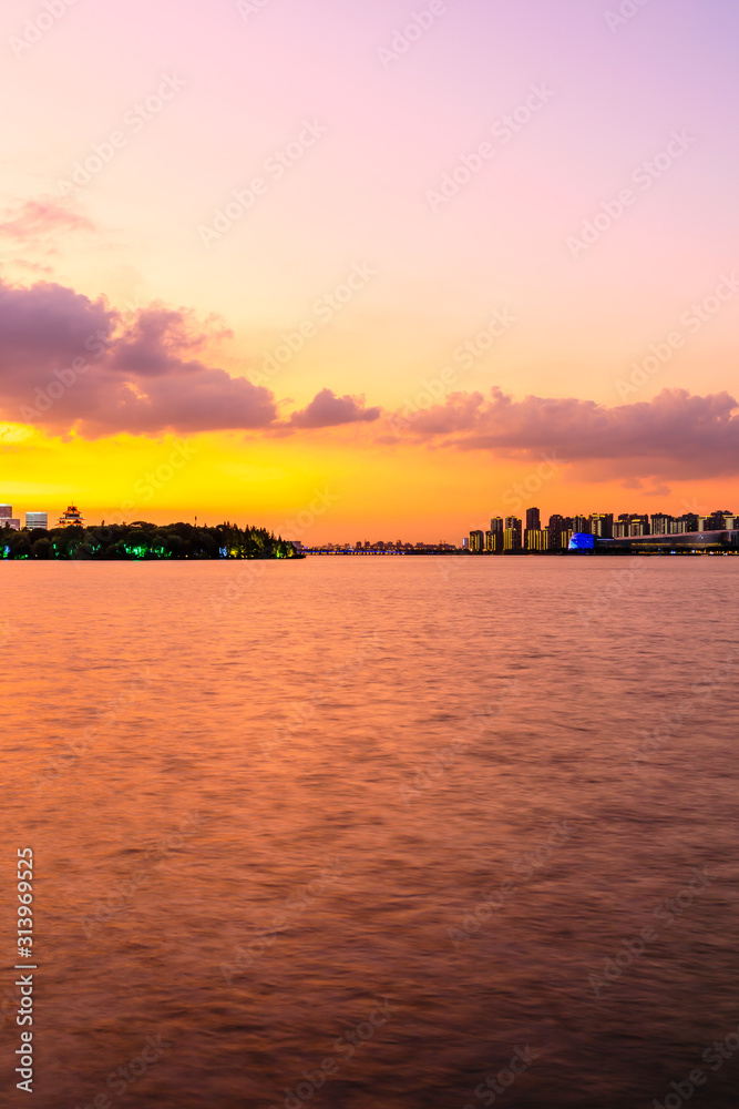 美丽的苏州城市天际线和日落时分的湖泊建筑，中国。