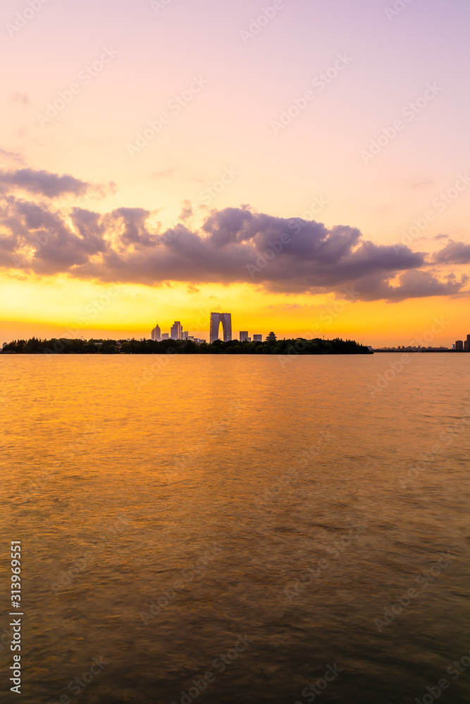 美丽的苏州城市天际线和日落时分的湖泊建筑，中国。