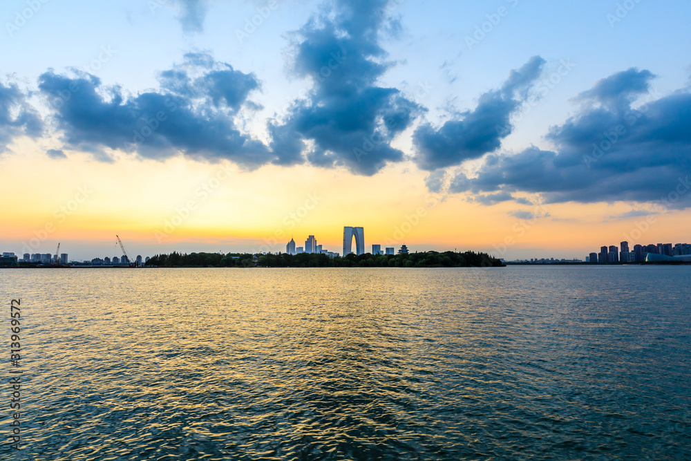 美丽的苏州城市天际线和日落时分的湖泊建筑，中国。