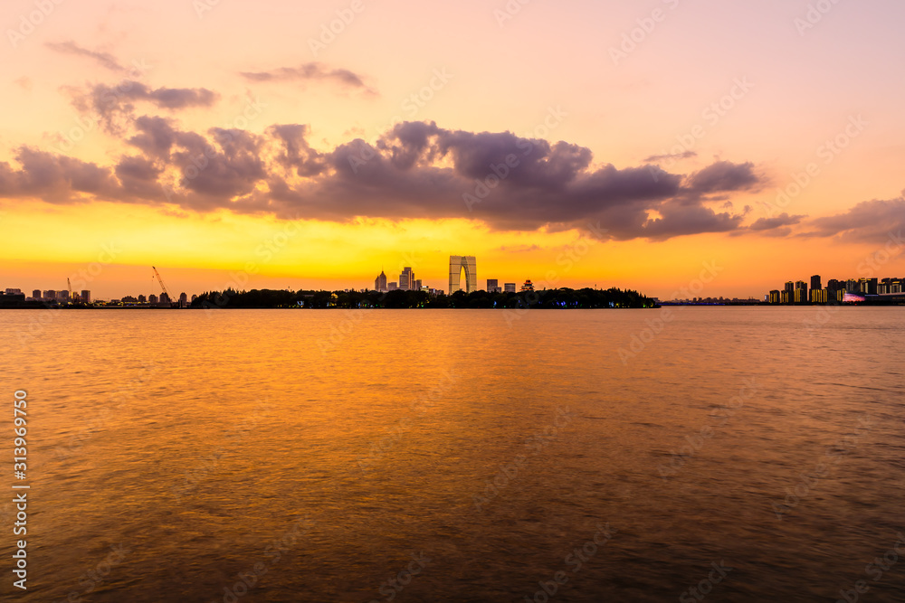 美丽的苏州城市天际线和日落时分的湖泊建筑，中国。