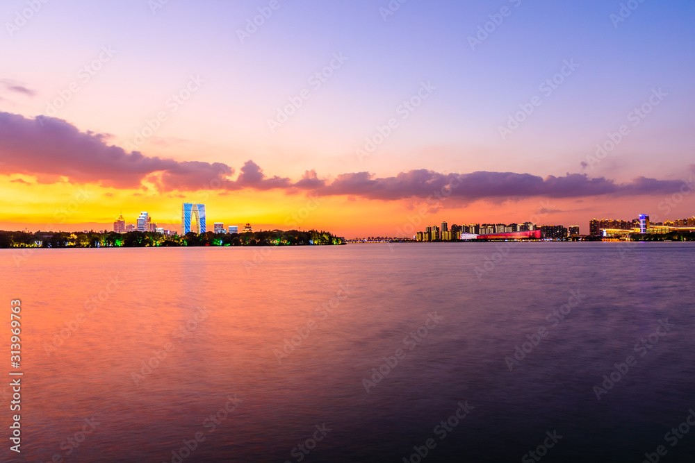 美丽的苏州城市天际线和日落时分的湖泊建筑，中国。